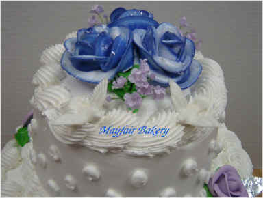 Lavender roses on top of wedding cake